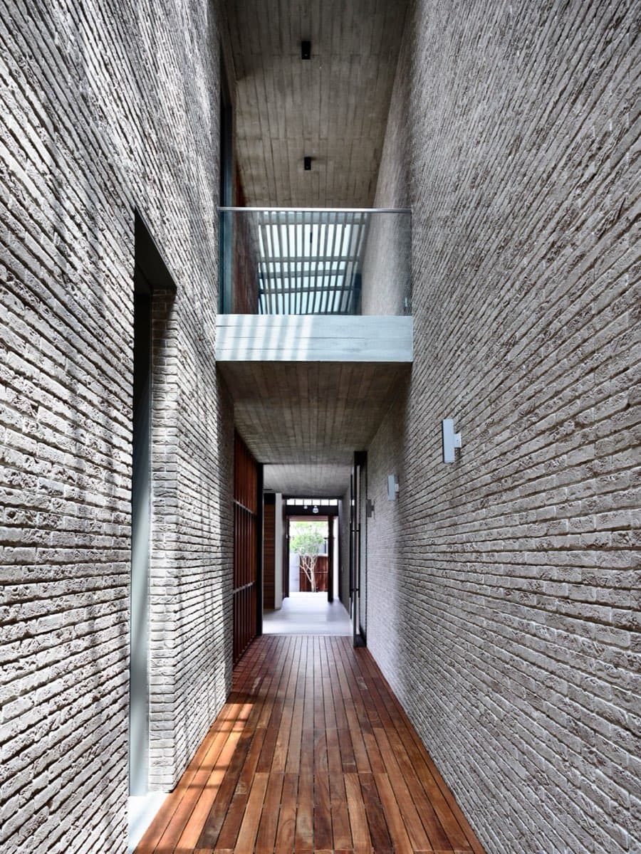 Textured brick corridor with timber flooring in a completed landed home