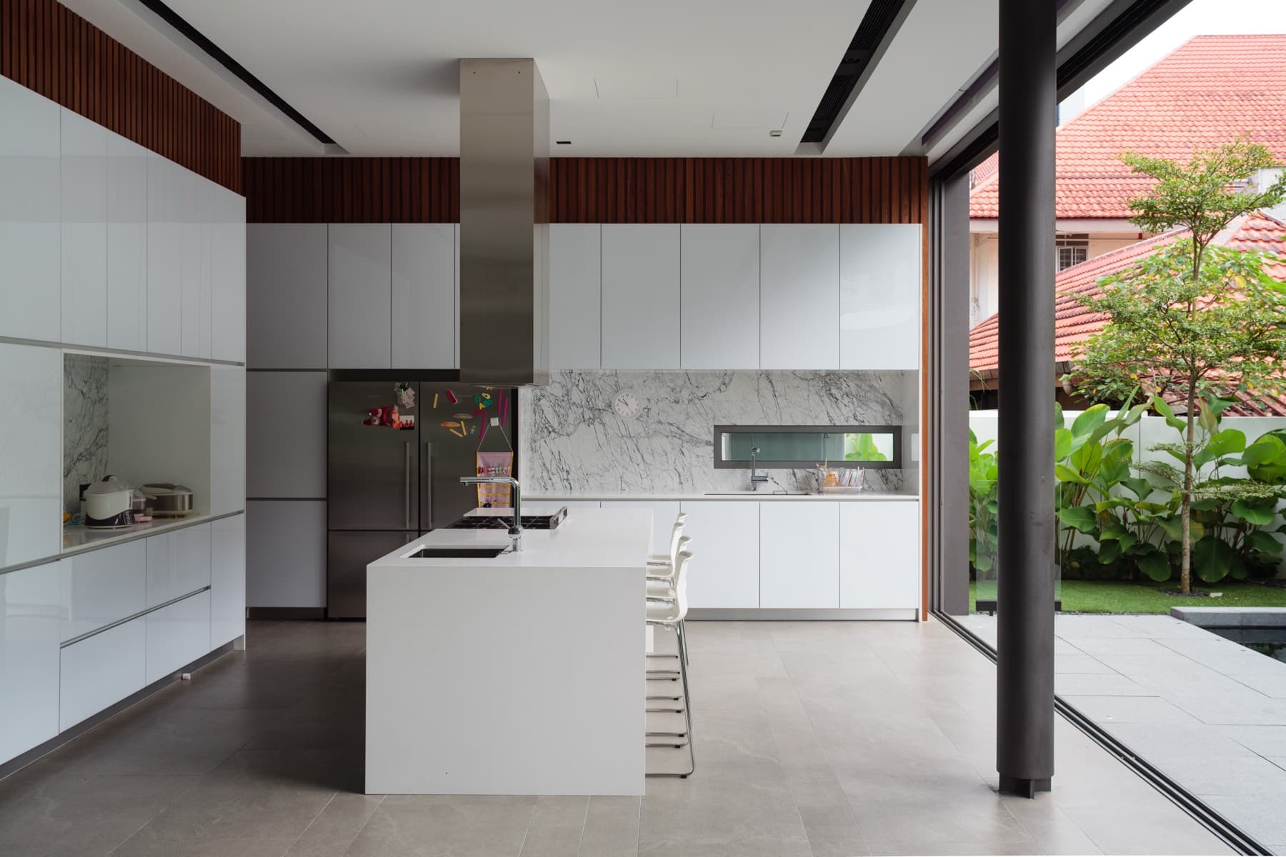 Open kitchen with marble splashback flowing to an outdoor courtyard