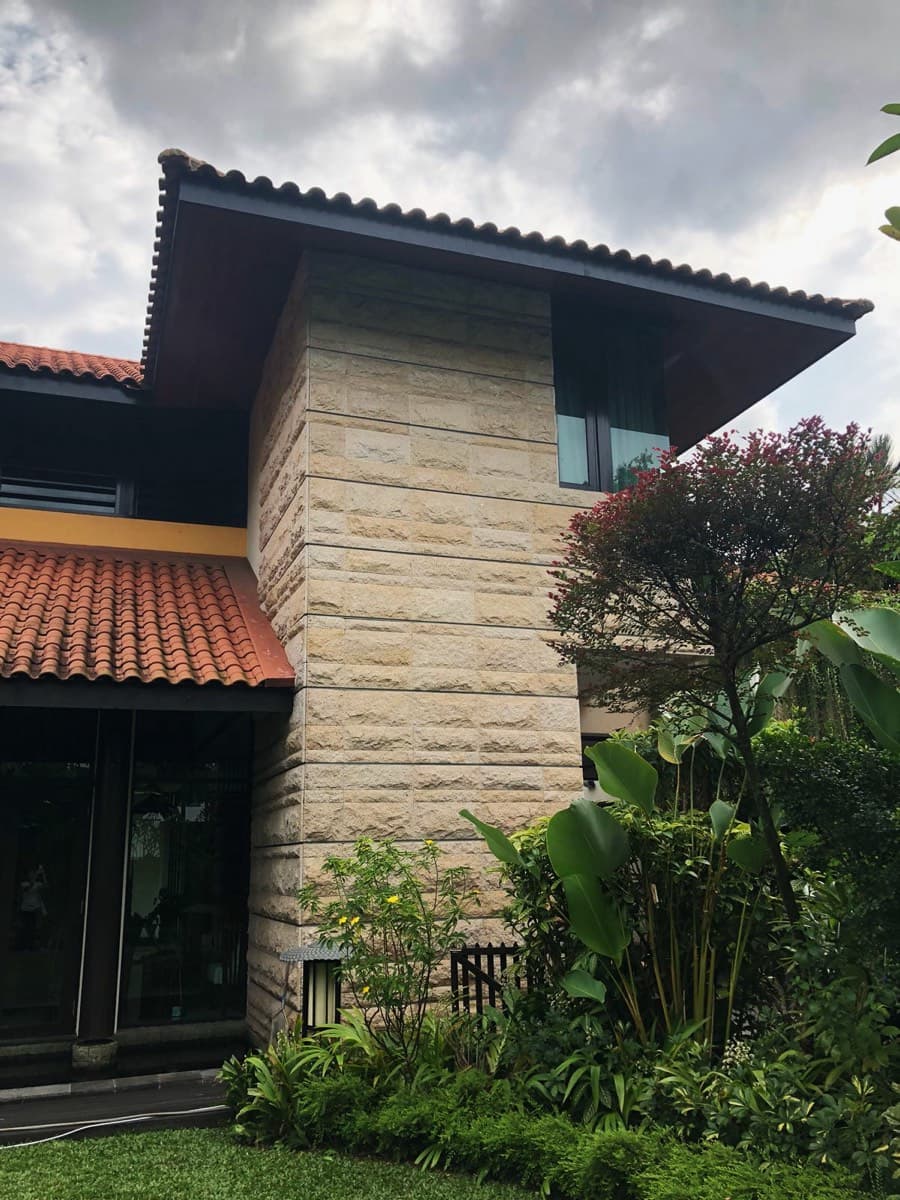 Pitched roof house with a natural stone feature tower